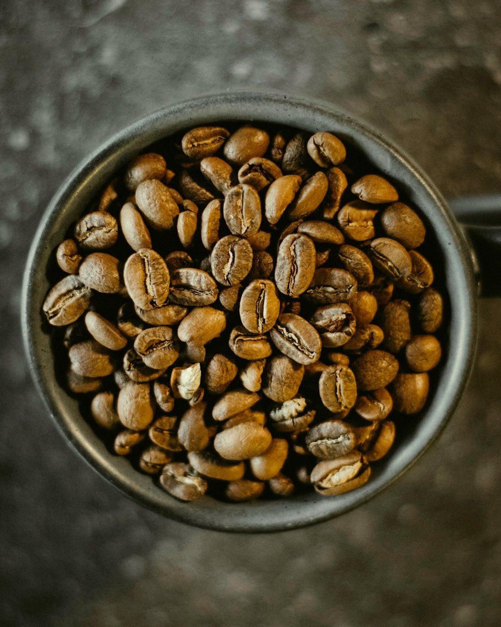 a cup filled with coffee beans on top of a table