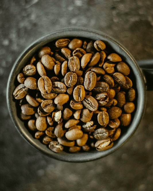 a cup filled with coffee beans on top of a table