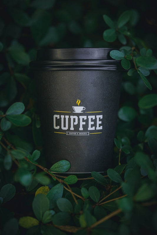 a cup of coffee sitting on top of a bush