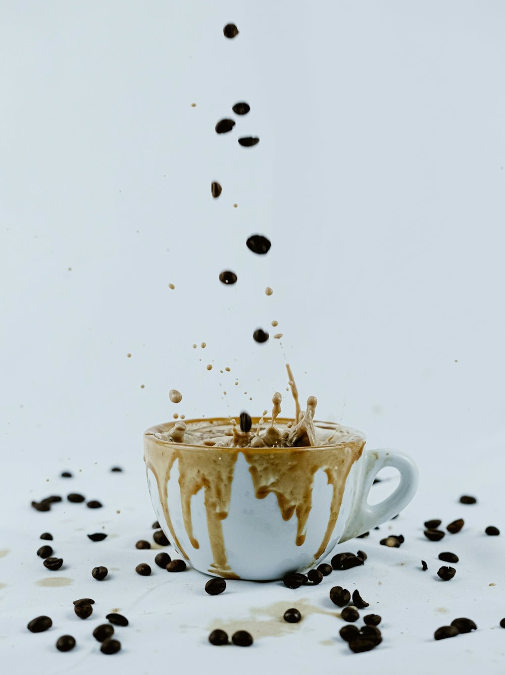 a cup filled with coffee beans falling into it