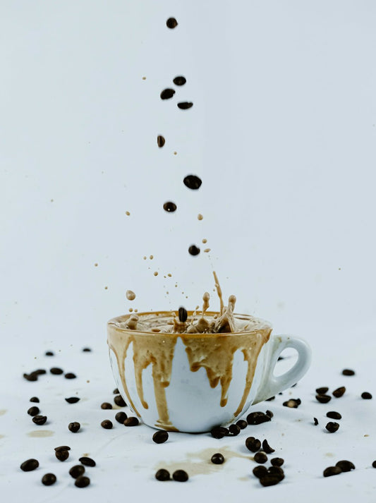 a cup filled with coffee beans falling into it