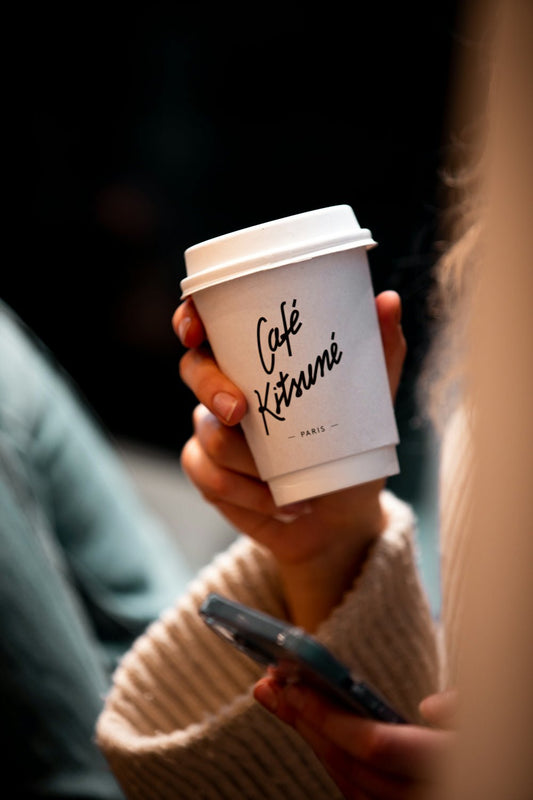 a woman holding a cup of coffee in her hand