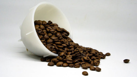 a white coffee cup filled with coffee beans