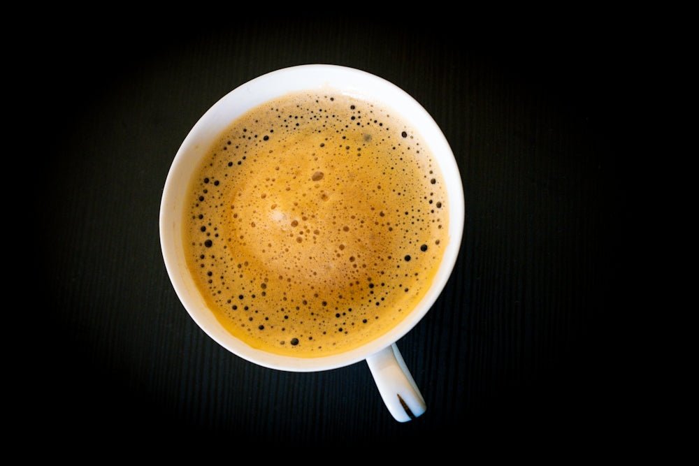 A cup of frothy coffee on a dark background
