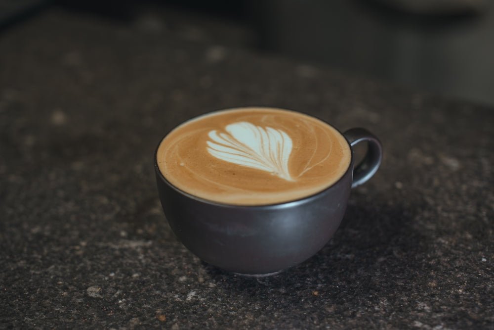 A dark mug filled with latte art coffee